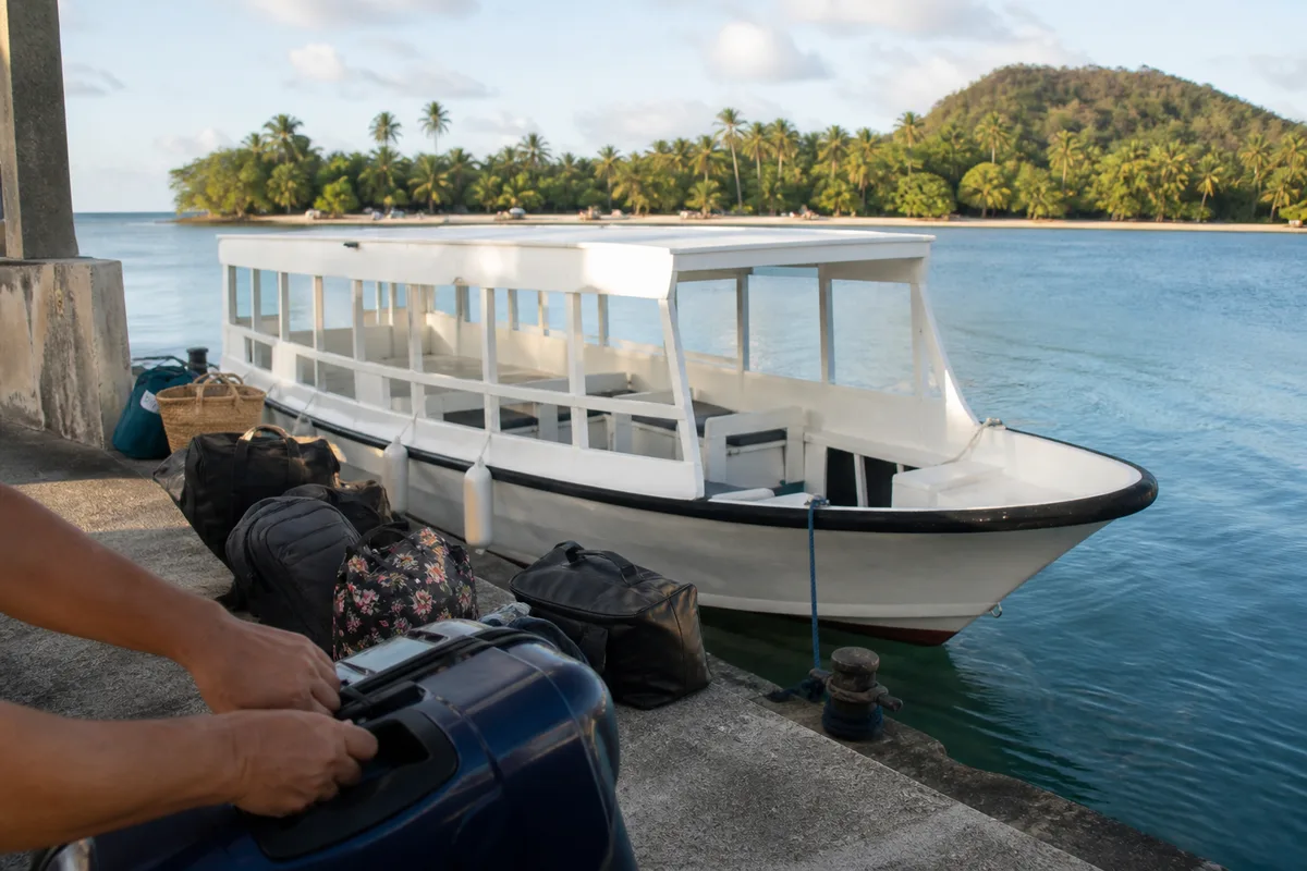 Ferry accostant à l&rsquo;embarcadère de Grande-Anse, passagers avec sacs de voyage sur le quai