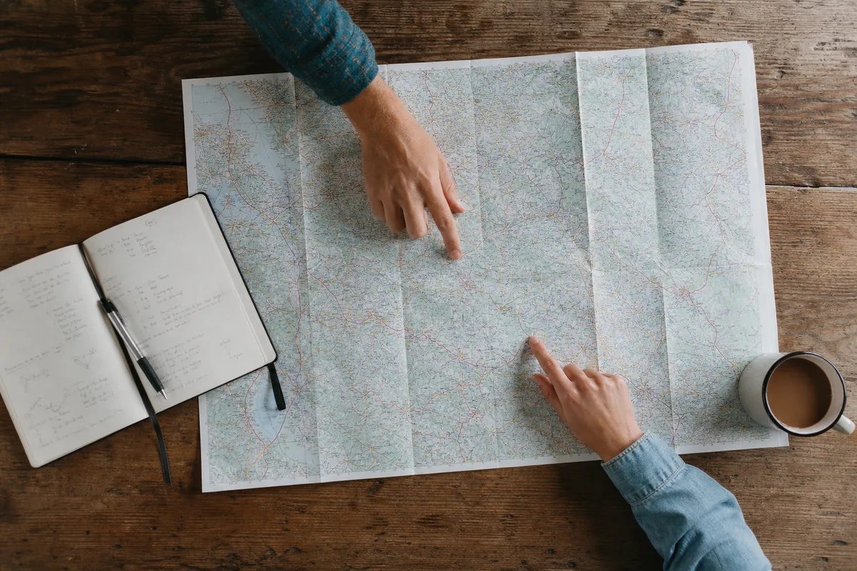 Carte routière de l’Ardèche posée sur une table avec carnet et stylo pour préparer un itinéraire